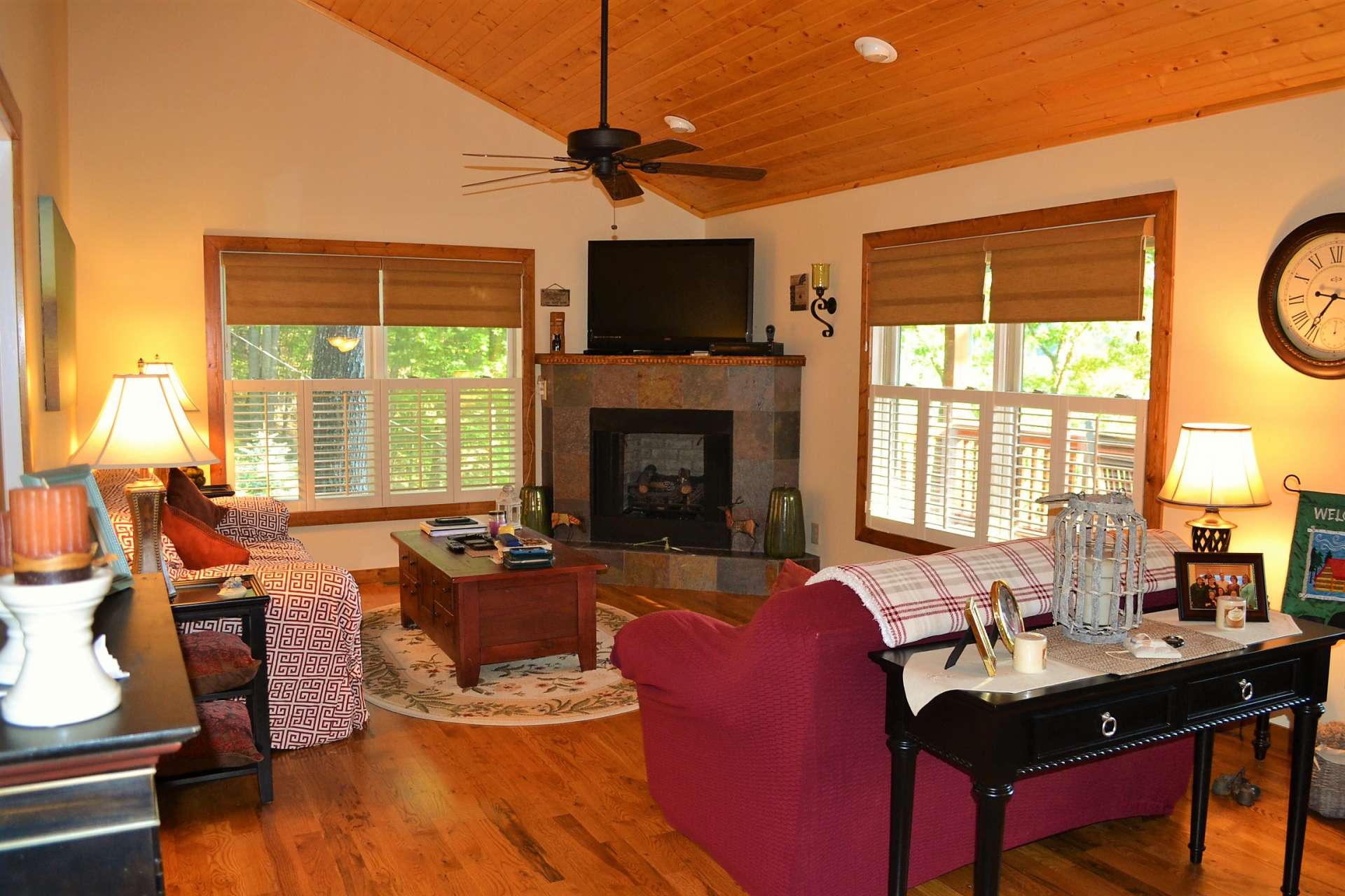 As you enter the front door, the vaulted wood ceilings and lots of windows keep the great room open and cheery, while the gleaming wood floors and fireplace with gas logs add warmth.