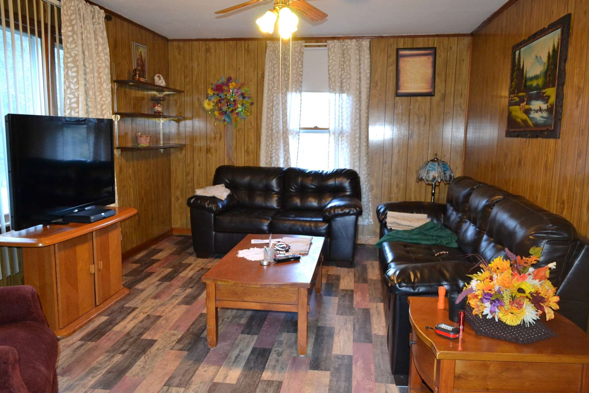 This is the living room with new vinyl flooring, paneled walls, and lots of character.