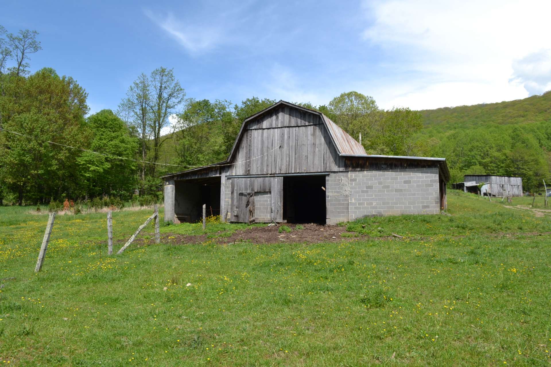 A large barn will be perfect for livestock, equipment storage, or crop harvest.  There is even a chicken coop and several other outbuildings essential for farm life in the country.