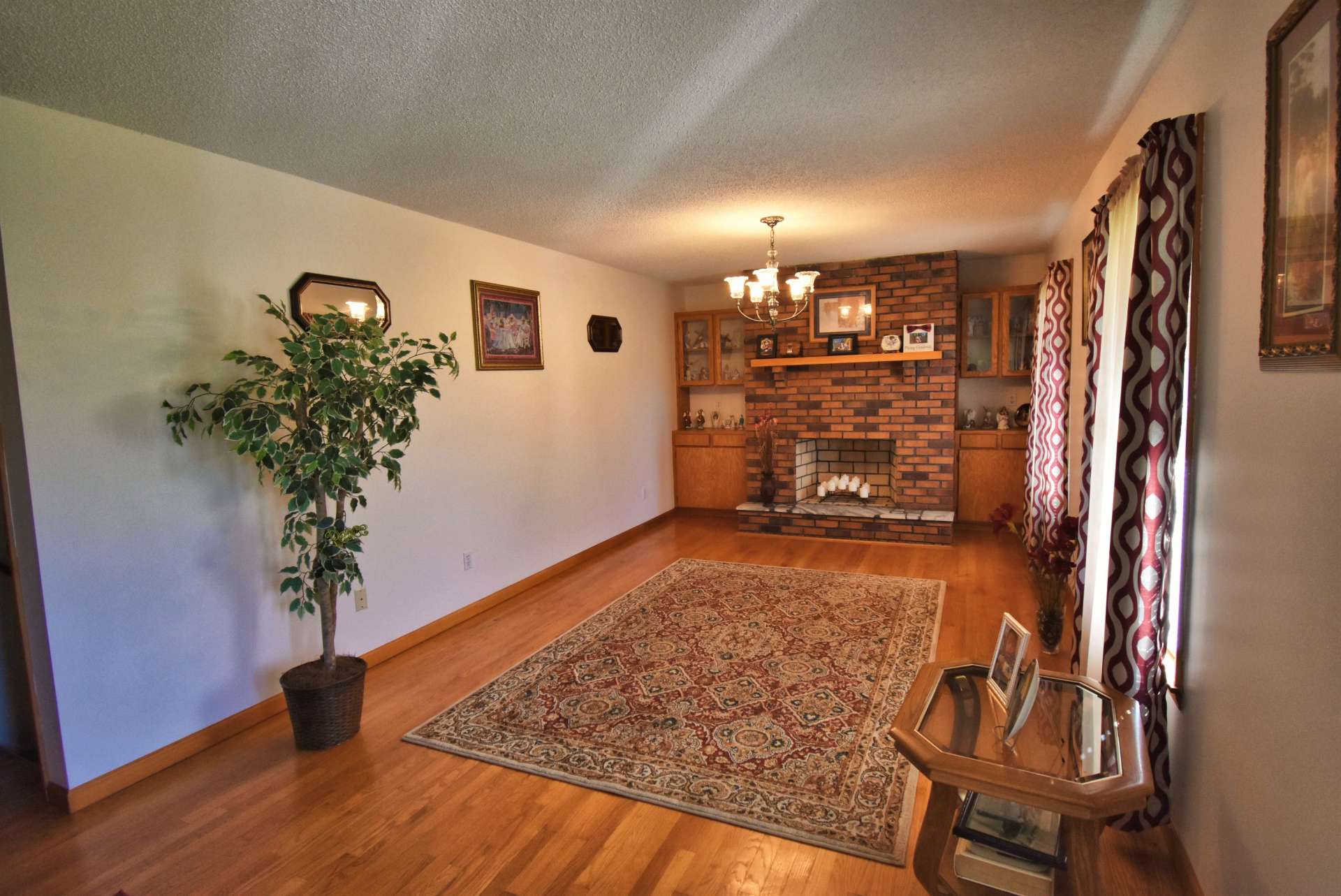 Relax by a crackling fire in the wood burning fireplace flanked by built-in cabinetry to showcase your collectables and photos. Notice the gorgeous hardwood floors.