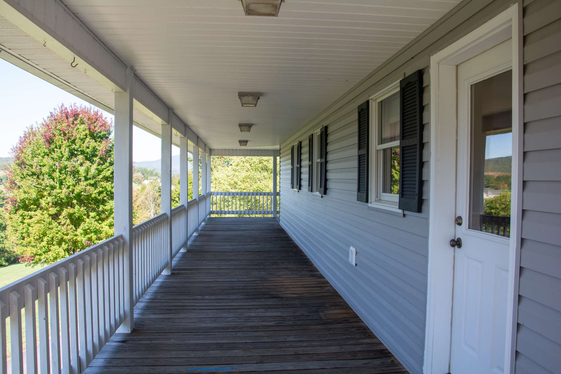 Covered porch on back of house offers easy access to kitchen making outdoor grilling a breeze.