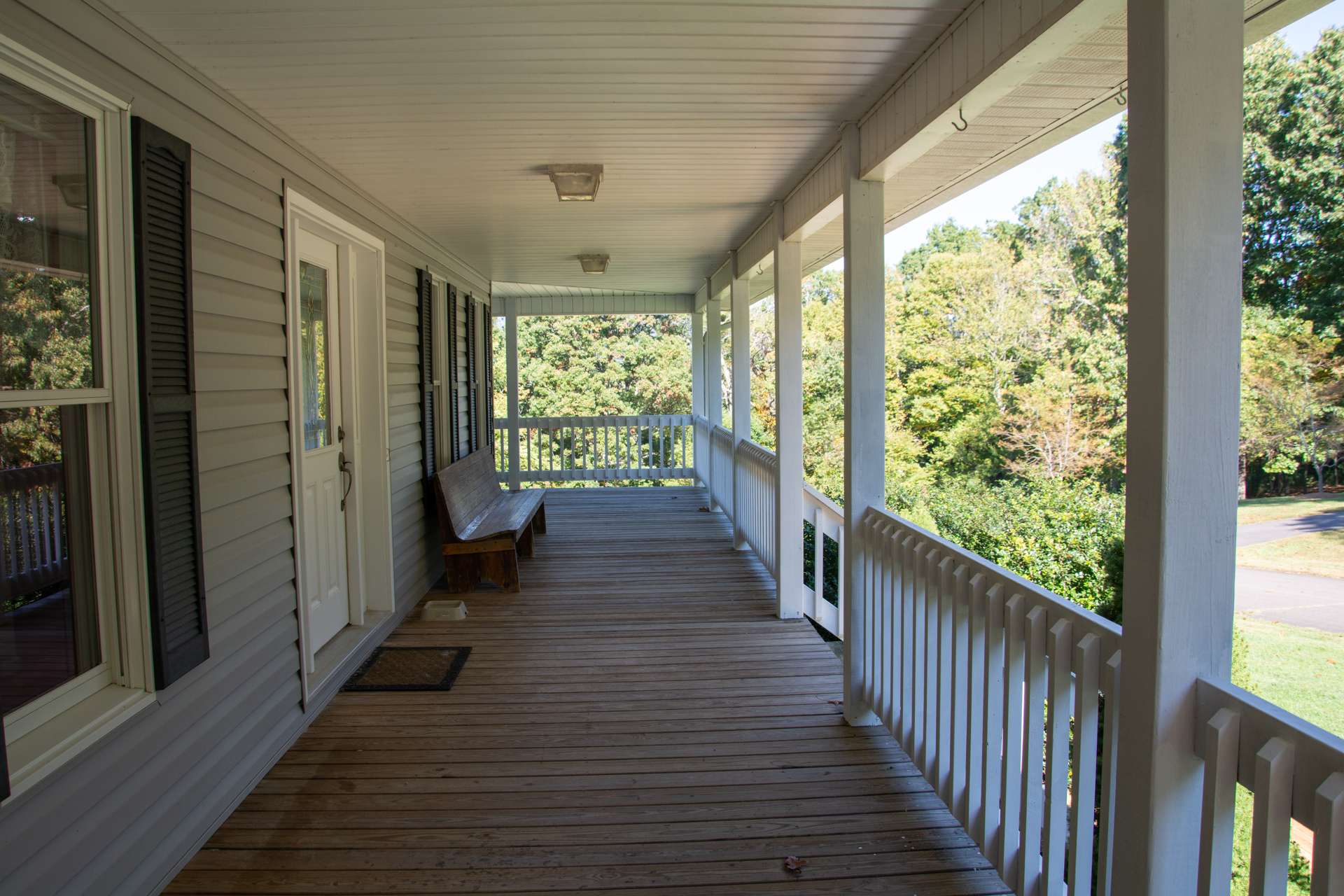 Covered porch on front of house welcomes neighbors and friends and provides shade on sunny afternoons.