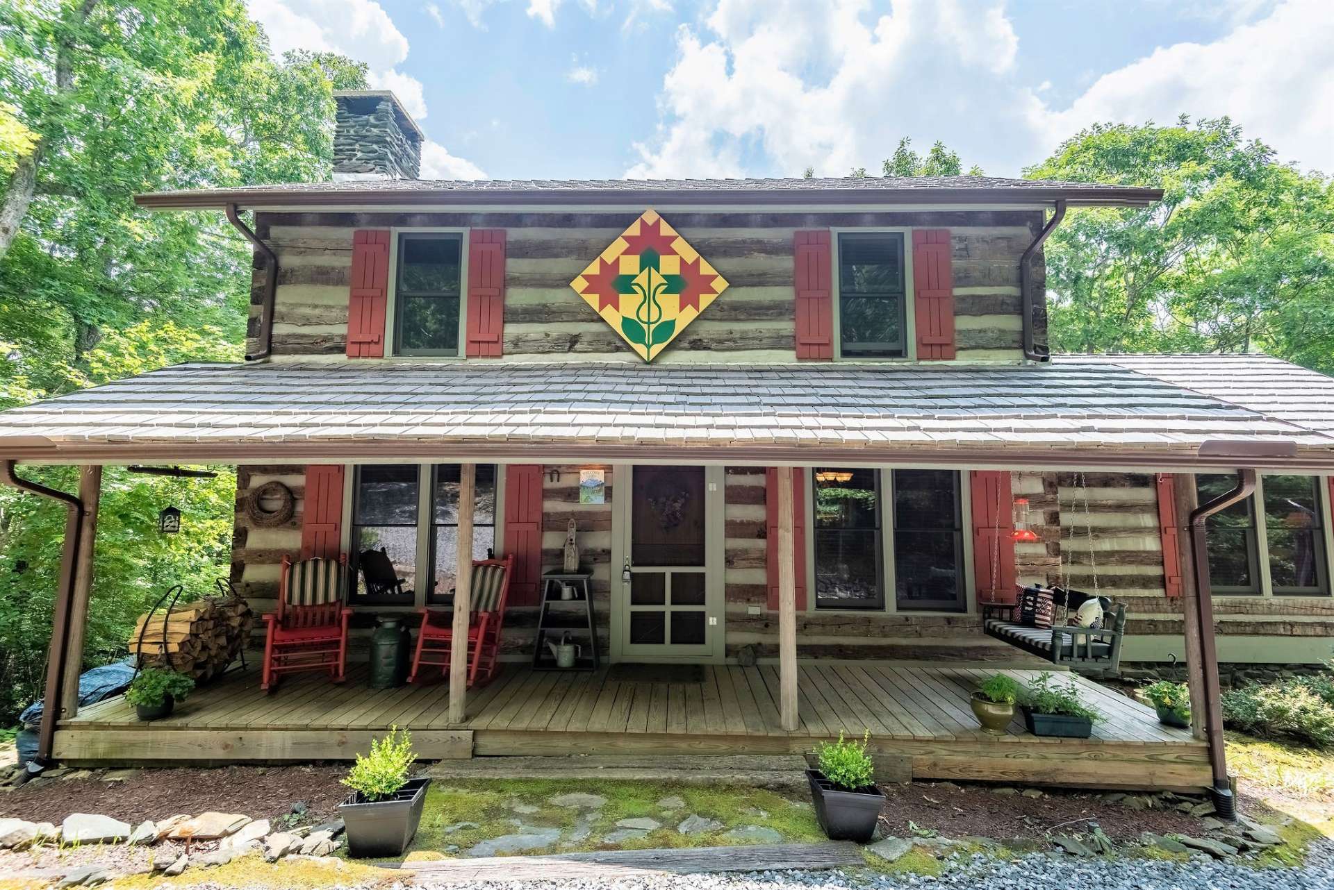 The cabin has a welcoming covered porch with swing and a pair of rocking chairs to relax and greet your neighbors.