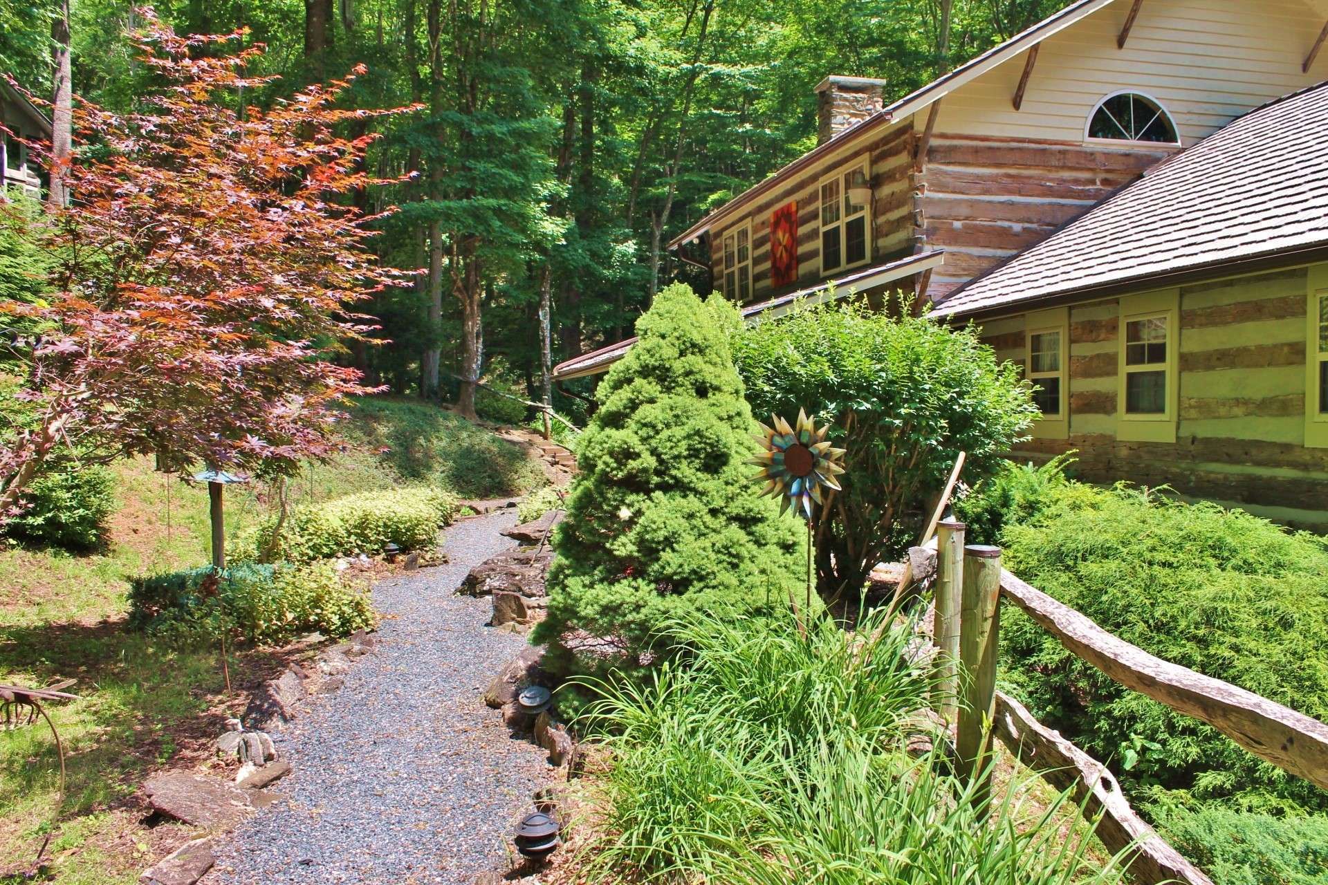 A professionally landscaped walkway leads you to the rocking chair front porch. Both the landscaping and porch enhances the rustic charm of the cabin.