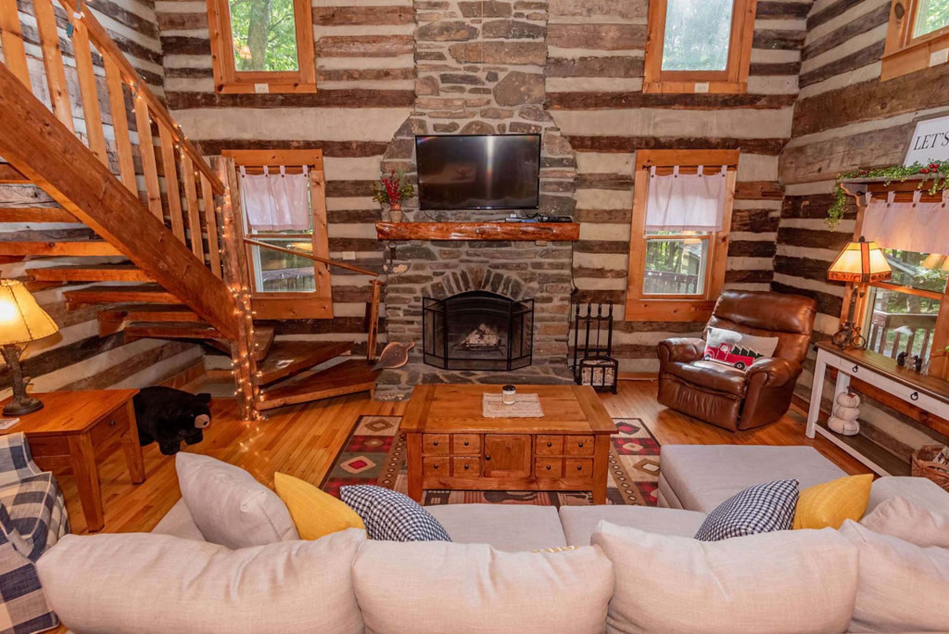 The mighty rock floor to ceiling fireplace, flanked by windows, is the focal point of the great room.