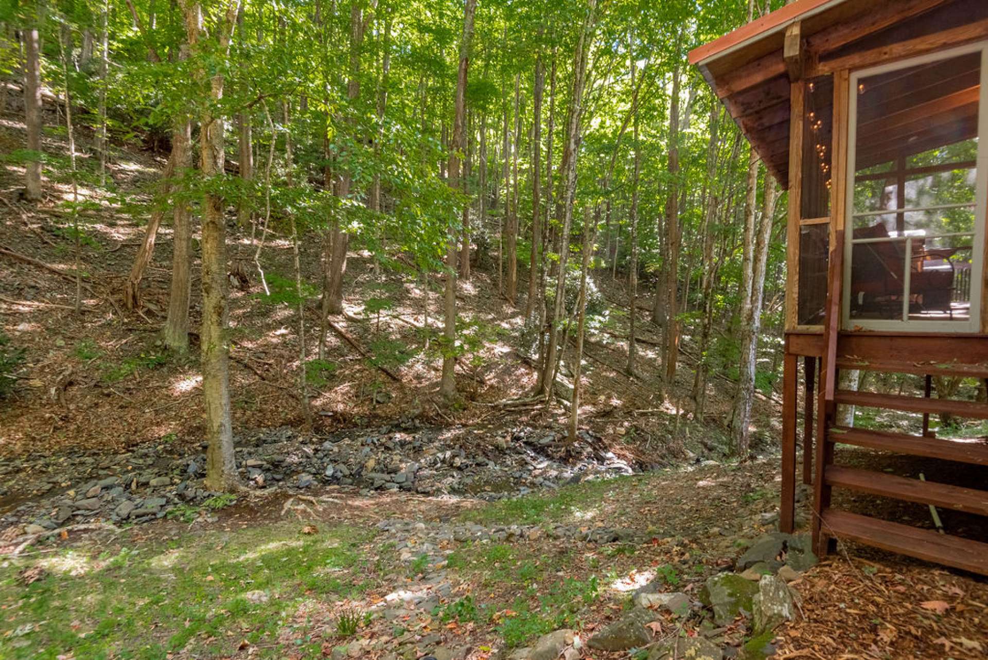 This Stonebridge log home is complete with its own mountain creek and rainbow trout pond.  No need for a sound app with this creek right behind your house.