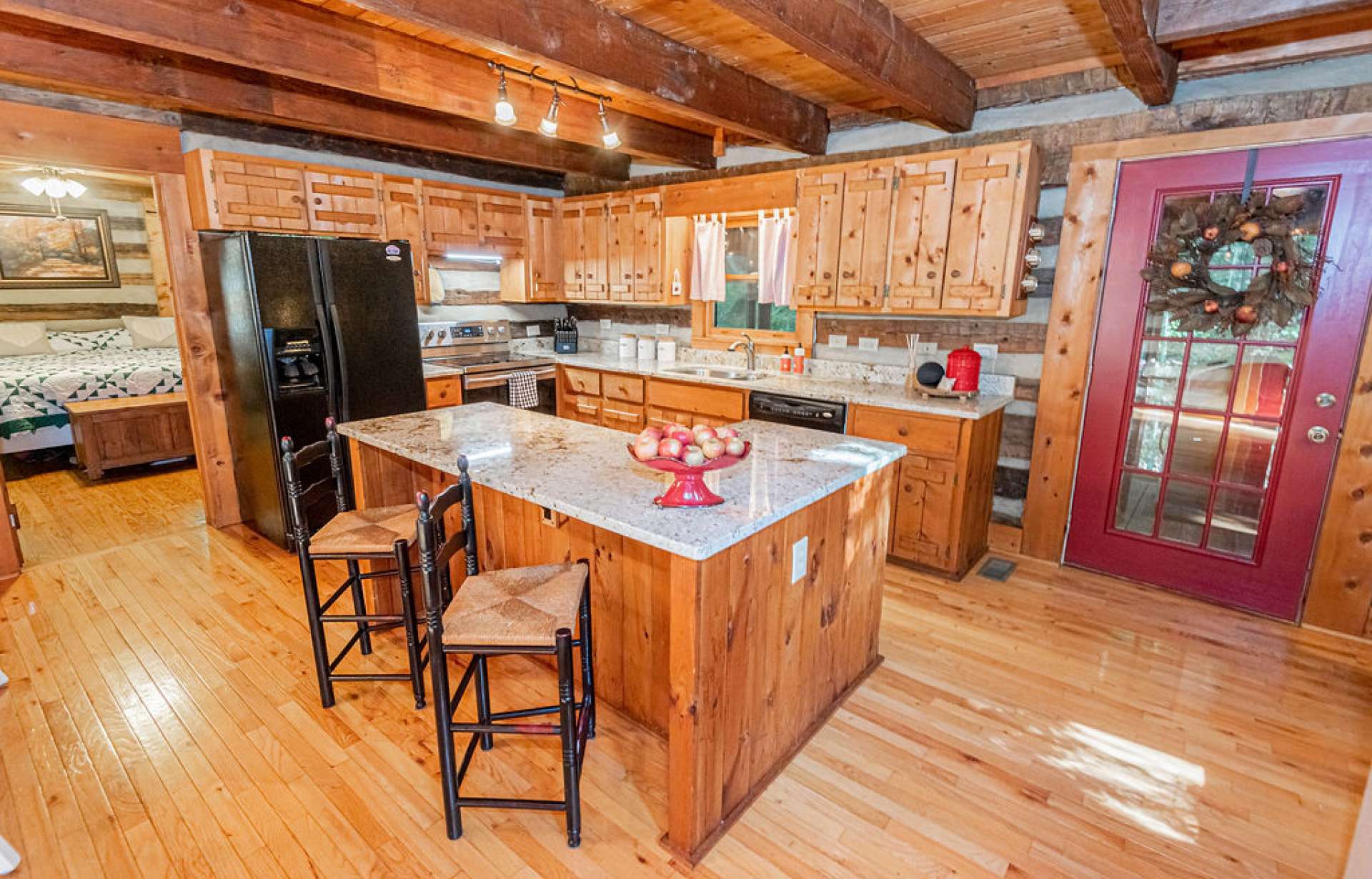 Kitchen is partitioned by a large island, offering seating and extra cabinet space.