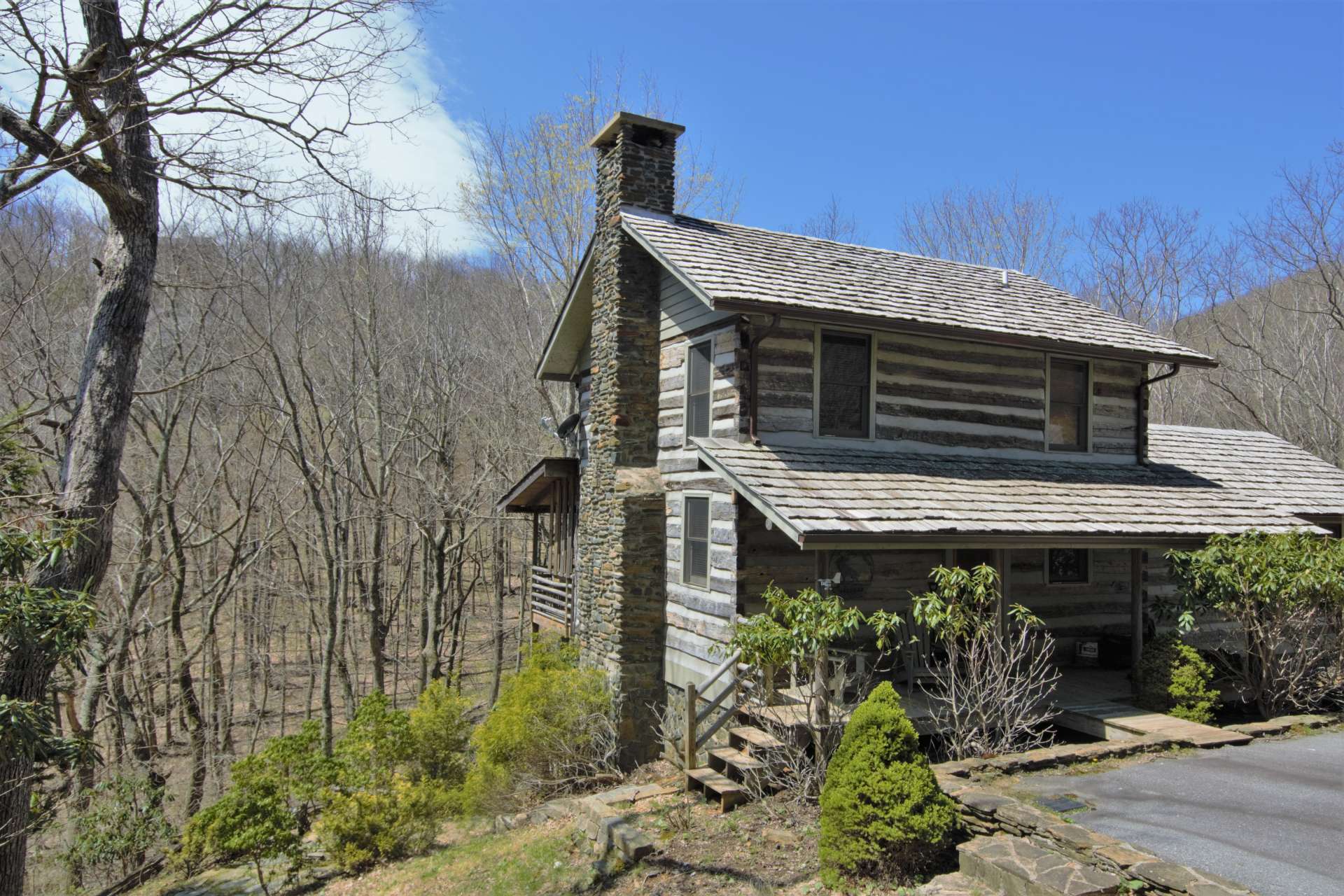 A covered front porch welcomes you and guests and invites you to relax with the wooded setting and sounds of the creek while experiencing true mountain log cabin living.