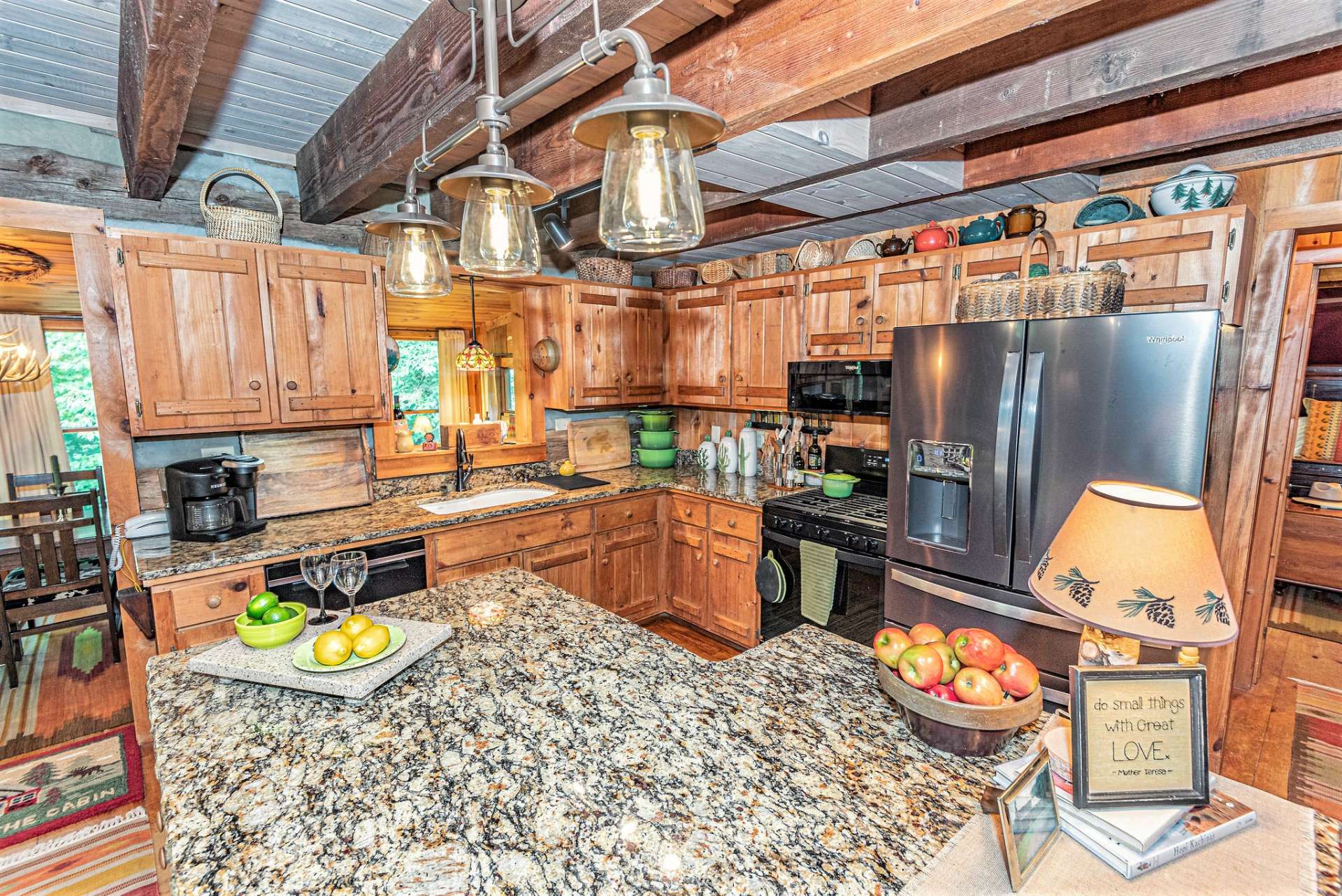 The kitchen has been upgraded with granite countertops with the center island having a special rough edge finish. Cabinets provide plenty of storage with convenient pullout shelving.