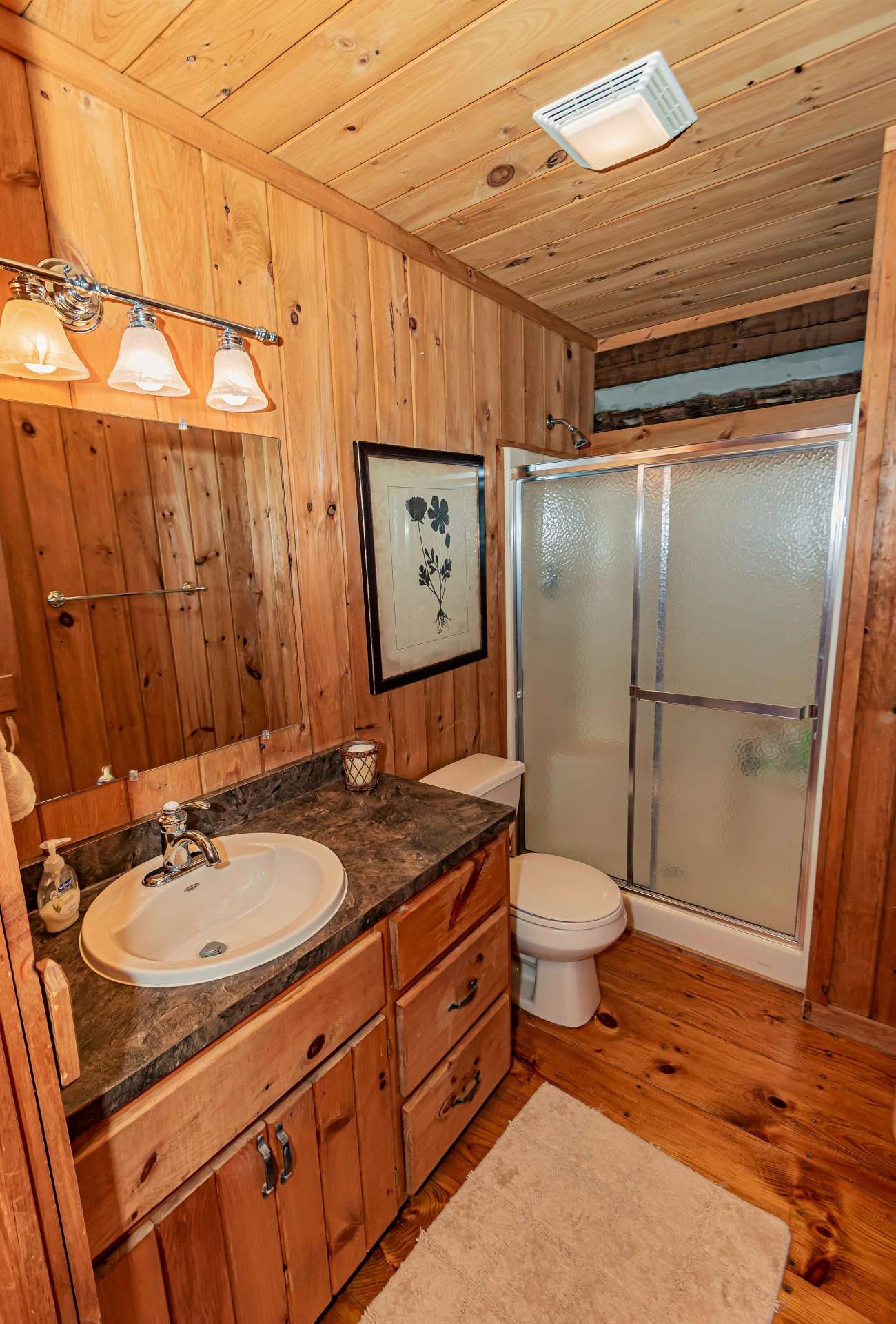 Main level bath is located off hallway between bedroom and kitchen. A closet with full size washer/dryer is across the hall.