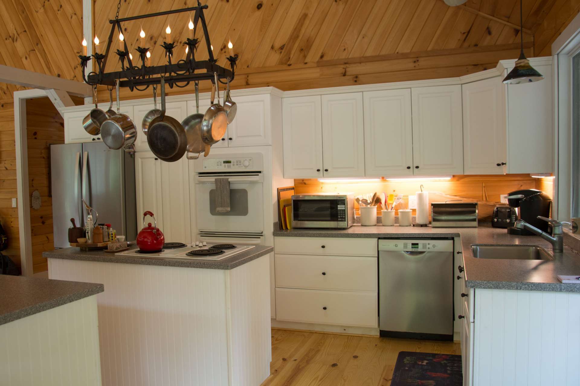 This efficient kitchen offers ample cabinetry, Corian counter tops, an island with bar seating, and plenty of space for help when preparing meals.