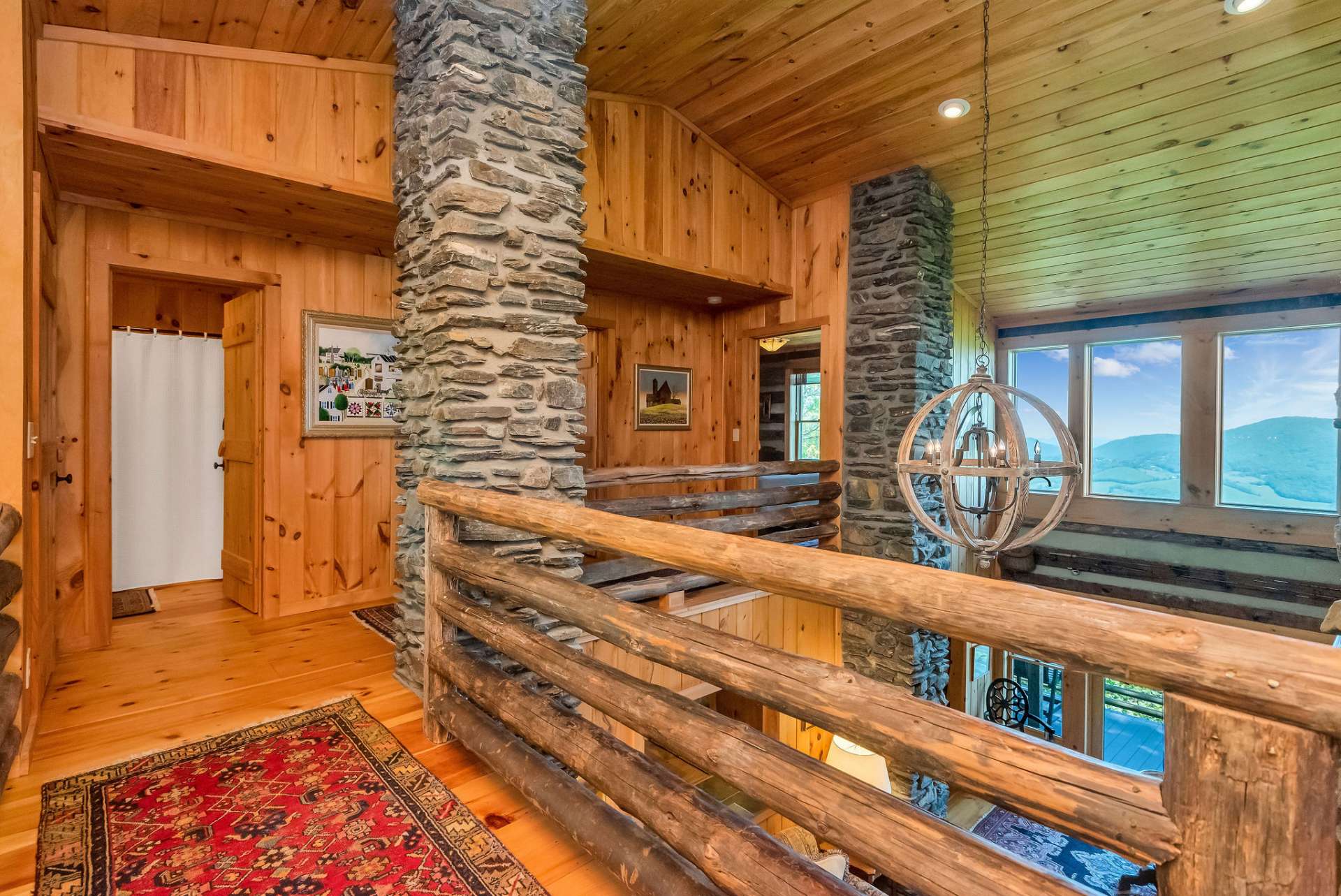 The four stone columns in the living area below extend through the upper level showcasing the unique design and rustic details of this Stonebridge cabin.