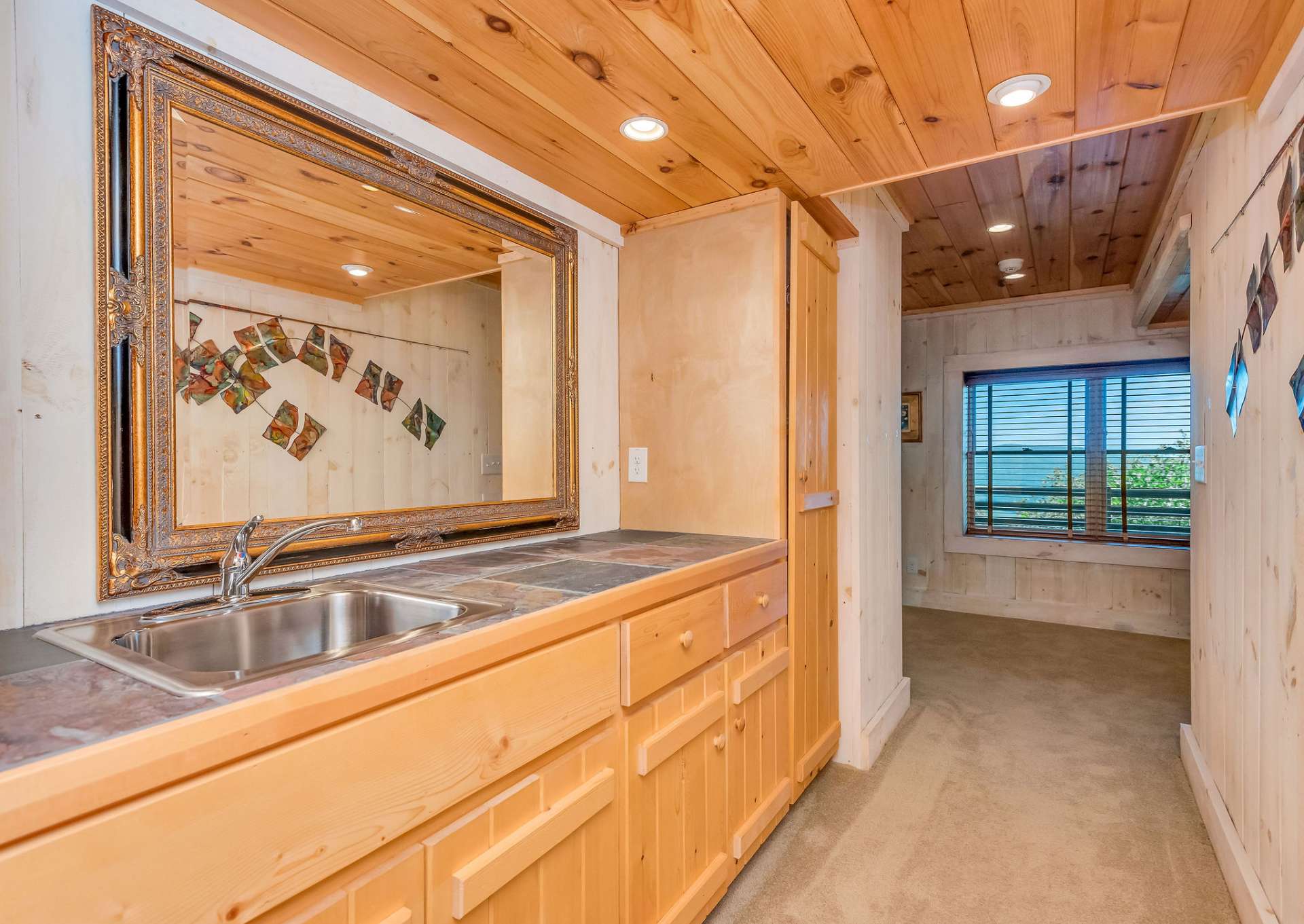 Lower level wet bar is located in hallway leading to family room.