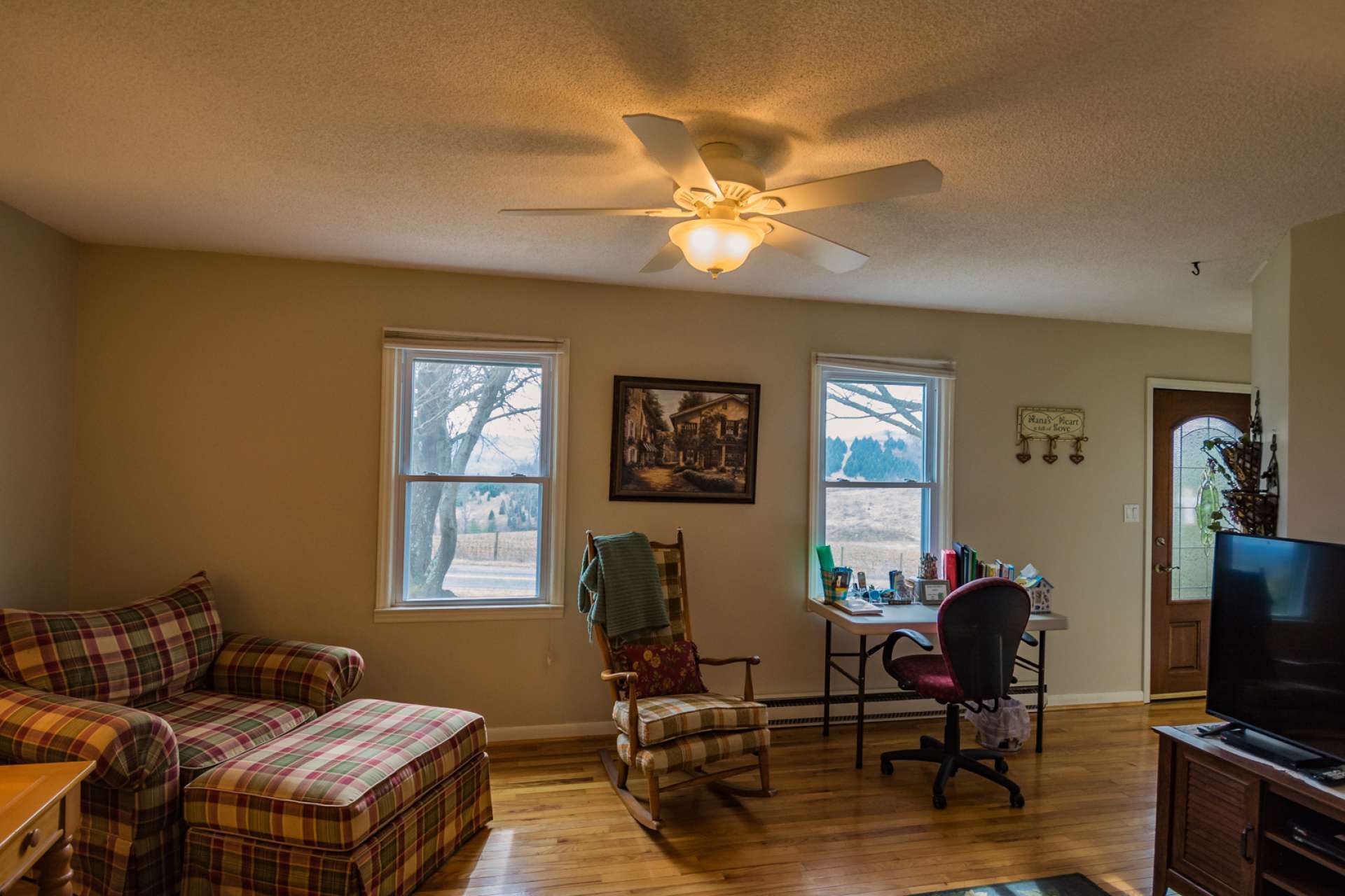 The spacious living room features beautiful oak flooring and lots of windows filling the room with natural light.
