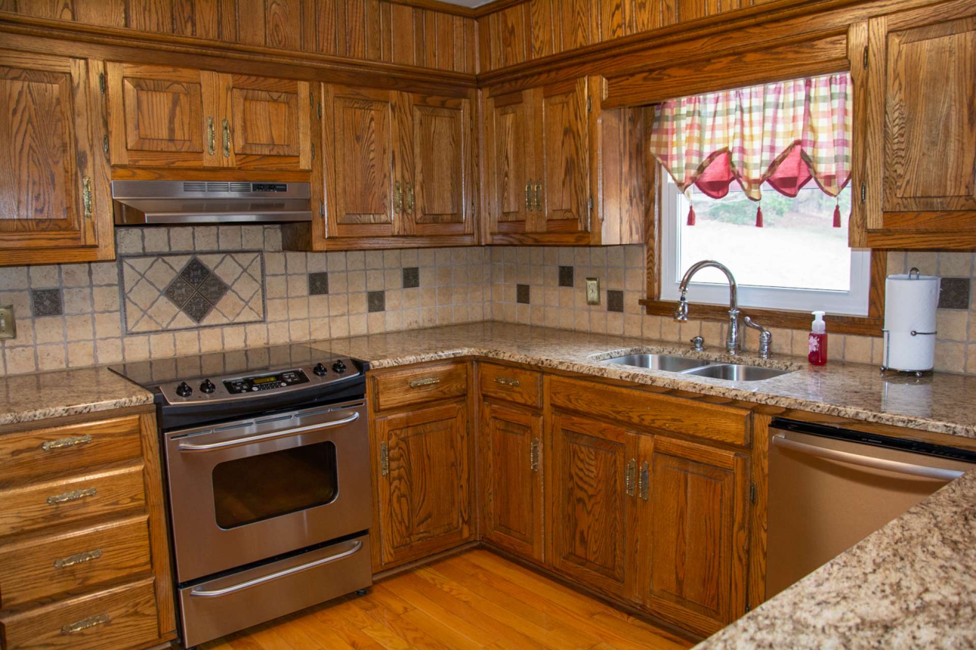 Kitchen features custom-built oak cabinetry, granite counter tops and stainless appliances.