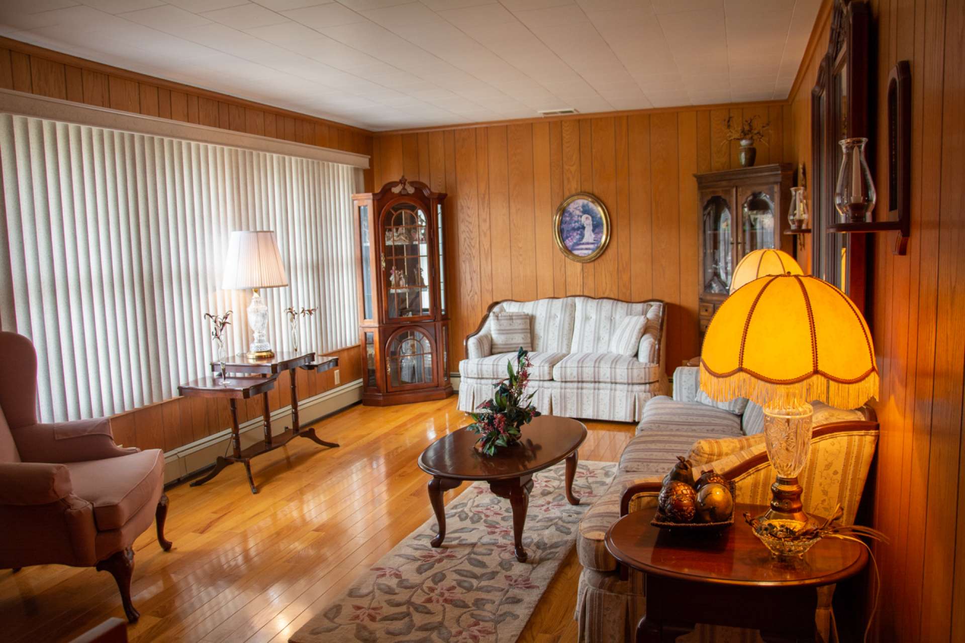 Spacious living room features paneled walls and same beautiful oak hardwood flooring.
