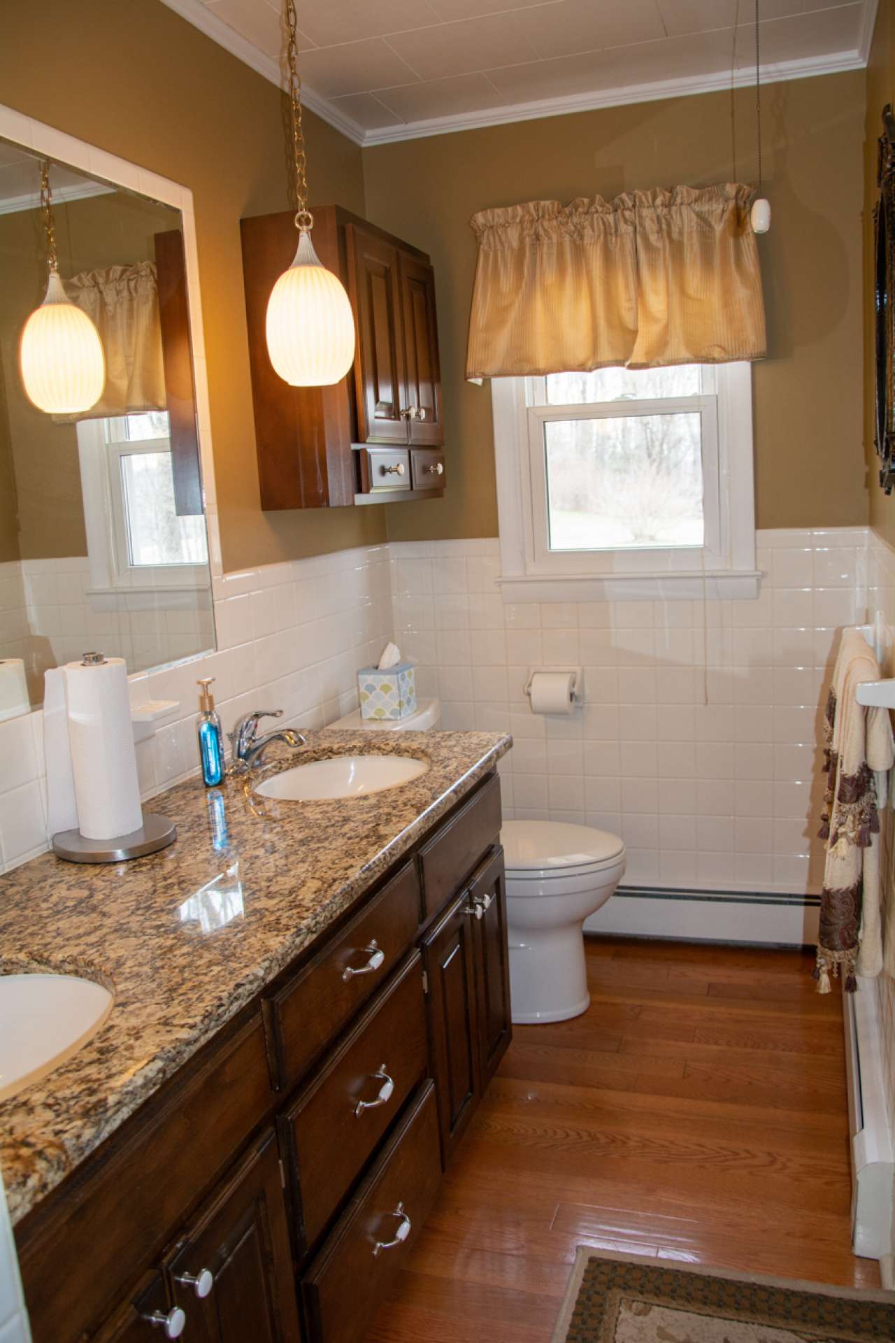 Full bath features granite counter top with double vanity and tile shower with bench seat.