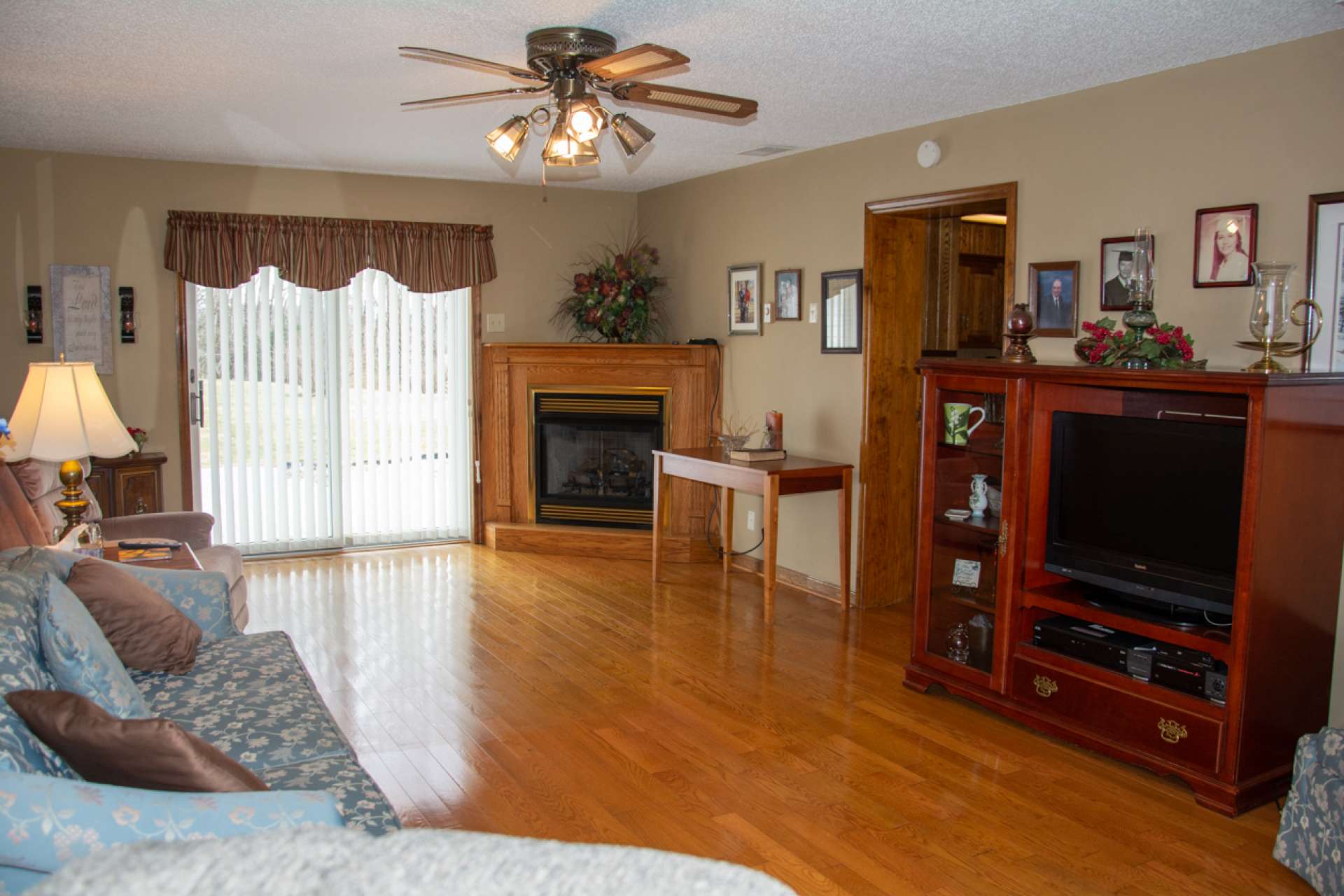Enter family room with gleaming hardwood flooring, cozy corner fireplace and access to back deck.