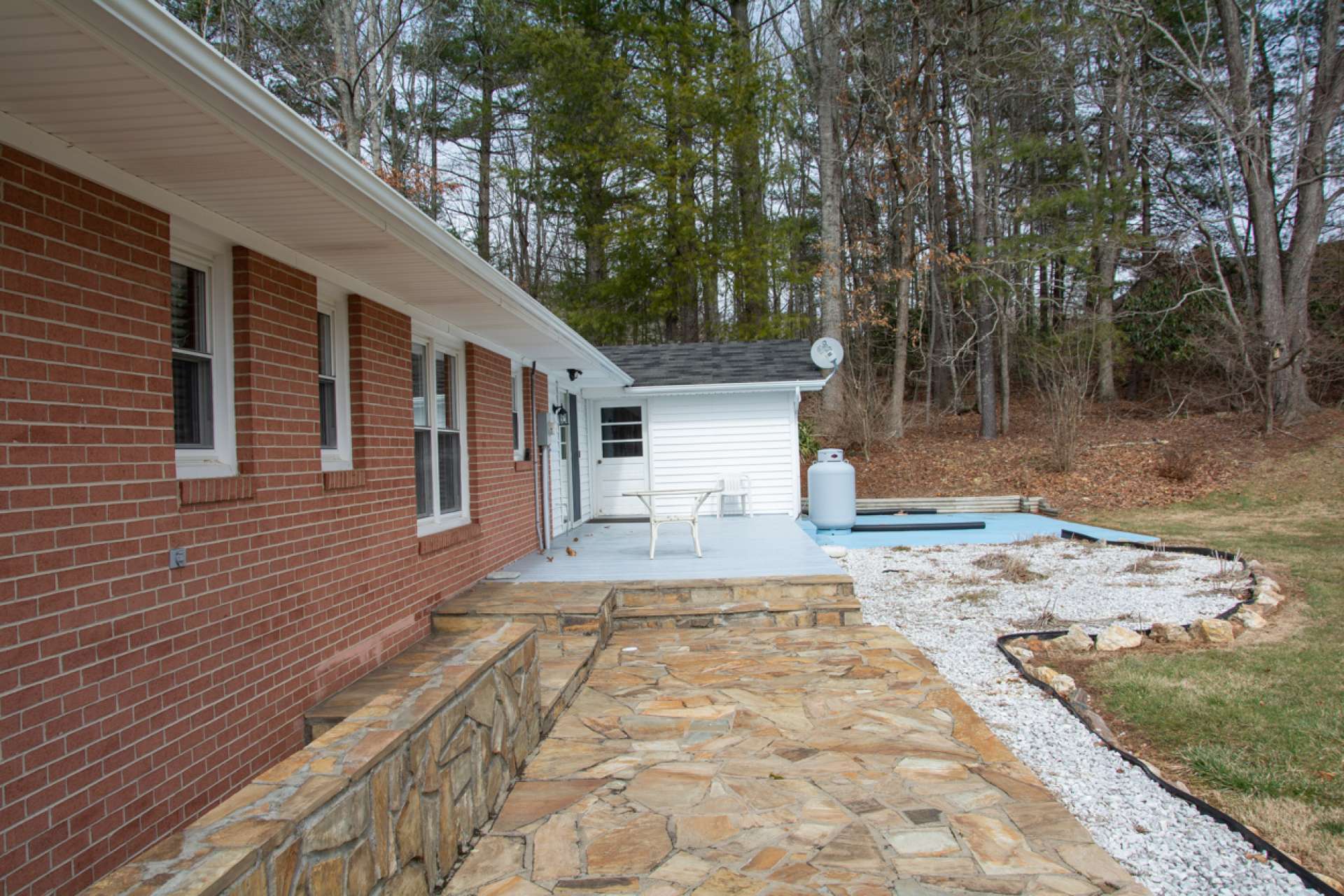 Stone patio and deck out back perfect for outdoor dining.