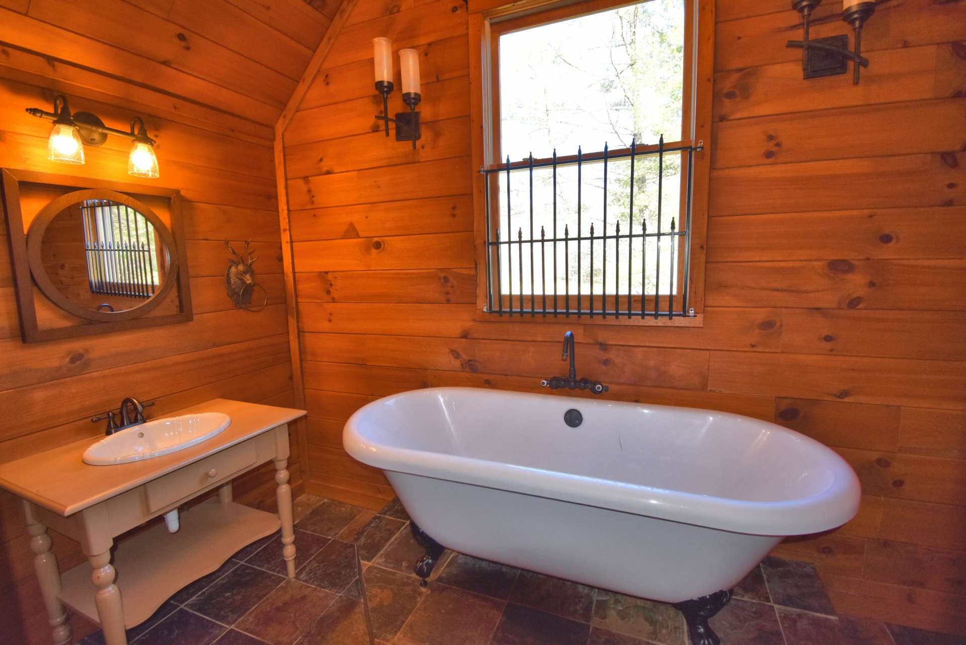 The upper level bath features a clawfoot tub and other custom details to enhance the cabin feel.