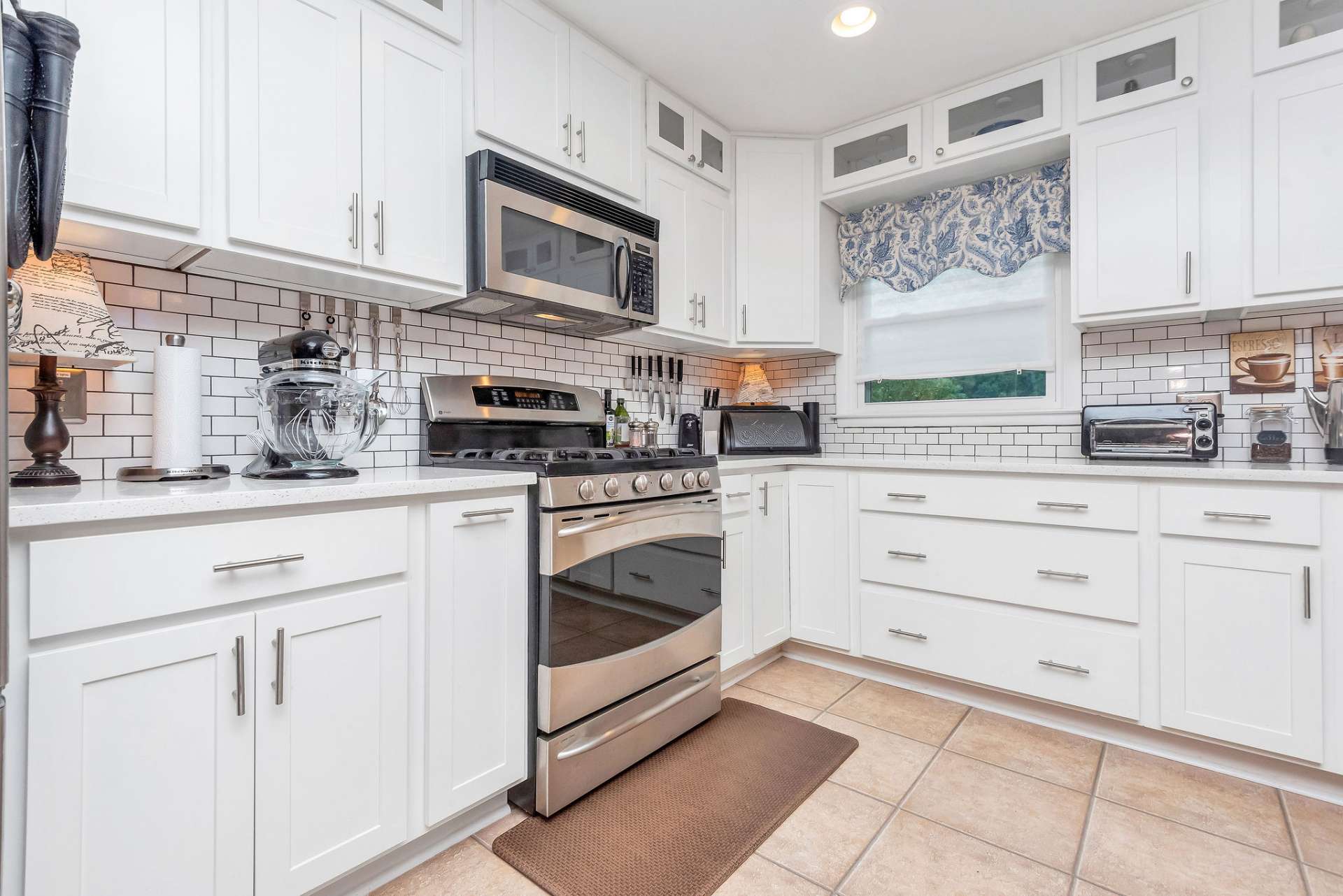 Solid surface countertops and white tile backsplash add to the open feel of the kitchen